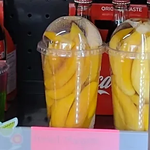 a display of bananas in plastic cups