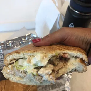 a hand holding a sandwich