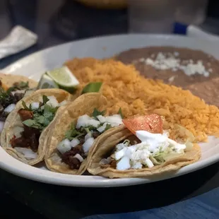 $1 tacos on taco Tuesday! Featuring al pastor, steak, chorizo, and chicken with a side of beans and rice