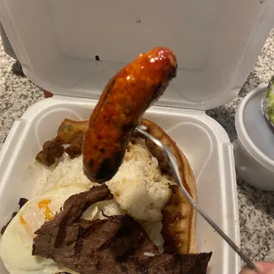 a hot dog and rice in a styrofoam container