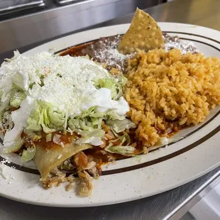 Red enchiladas combination with everything (lettuce, queso cotija, and sour cream)