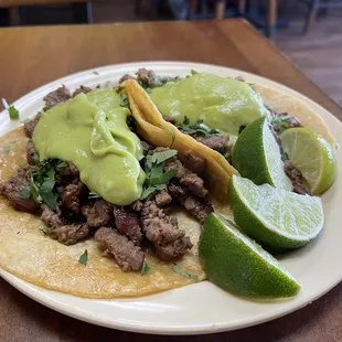 Tacos Asada with mashed avocado, cilantro, and lime on the side