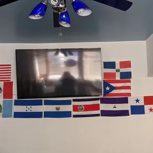 a flat screen television with flags on the wall