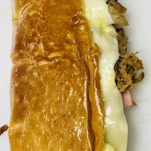 a meat and cheese sandwich on a cutting board