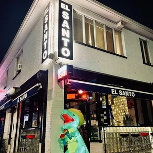 a dinosaur statue in front of a restaurant
