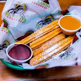 a plate of churros and dipping sauce