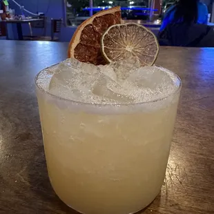 a close up of a margarita with a grapefruit garnish