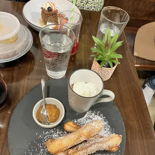 a plate of churros and a cup of coffee