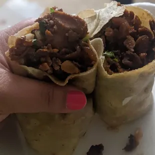 a hand holding a burrito