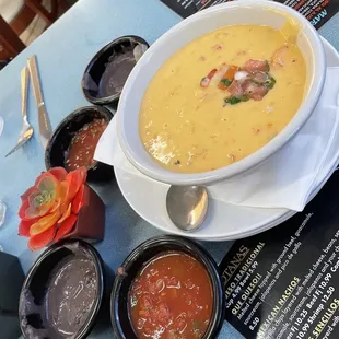 a bowl of soup and bowls of salsa