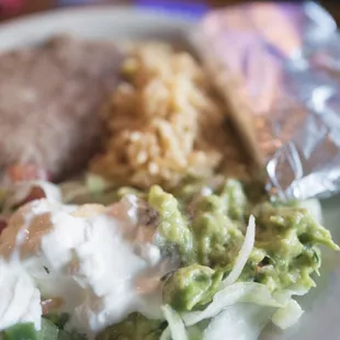 Fajitas come with sour cream, guac, homemade tortillas, pico de gallo, rice, and beans.