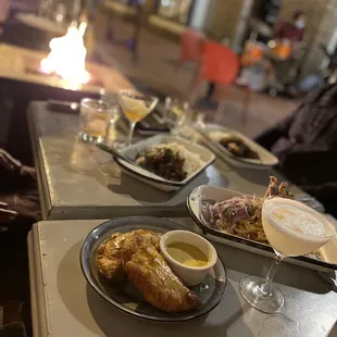 Duo of empanadas with aji de gallina and lomo saltado in the front, lomo saltado entrees in the back
