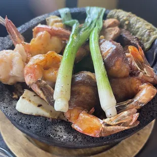 Mar y tierra molcajete. Base is green chile sauce which is SPICY.
