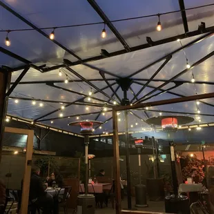 an outdoor restaurant with string lights