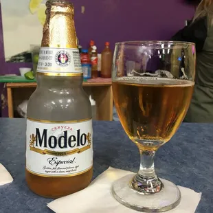 a glass of beer and a bottle of modelo