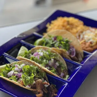 three tacos on a blue tray