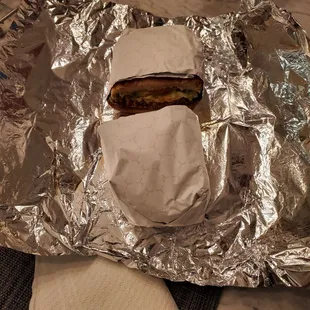 a sandwich wrapped in aluminum foil