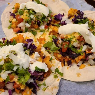 Fish tacos topped with sour cream, lime and extra onions and cilantro. Very good