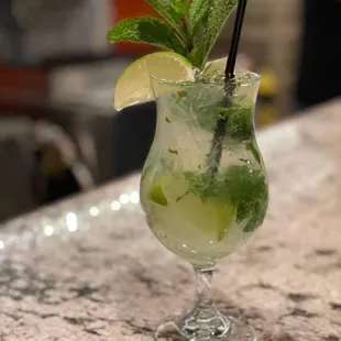 a glass of mojita on a bar