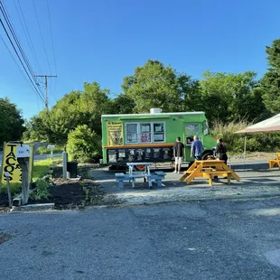 a man and a woman standing in front of a food truck