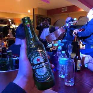 a person holding a bottle of heineken