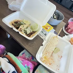 Two carne asada taco and elote.