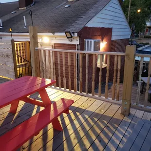 a red picnic table on a deck