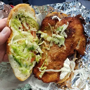 a hand holding a sandwich