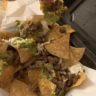 a hand picking up a tortilla