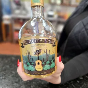 a woman holding a bottle of tequila