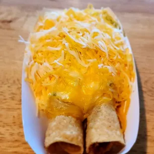 Steak taquitos with cheese, sour cream, guacamole