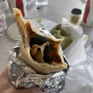 a hand holding a burrito