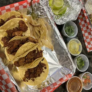 a tray of tacos and sauces