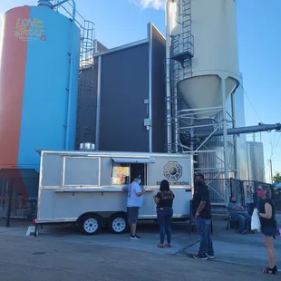 a group of people standing in front of a food truck