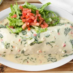 a plate of enchiladas with a side of guacamole