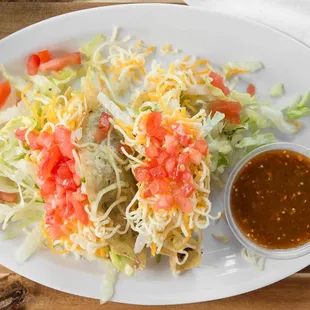 a plate of taco salad with a side of guacamole