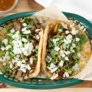 two tacos in a basket with guacamole