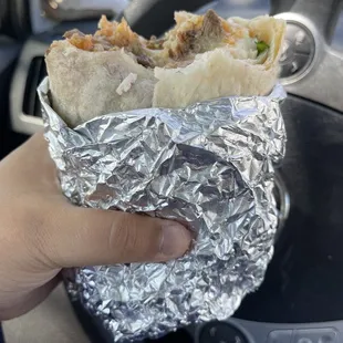 a hand holding a burrito