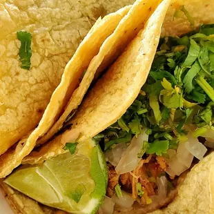 two tacoss in a styrofoam container