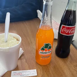 a bottle of soda and a cup of ice cream