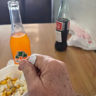 a hand holding a spoon over a bowl of food