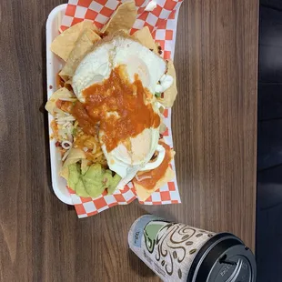 Chilaquiles with chorizo topped with two over easy eggs. Sour cream and guacamole added. Cafe de Olla was spectacular in the morning.