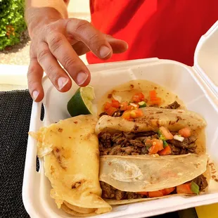 a hand reaching for a taco