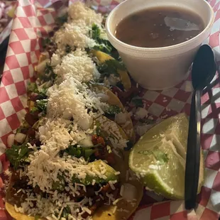 a plate of tacos and a bowl of sauce