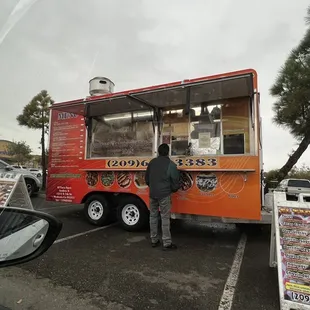 a man standing in front of a food truck