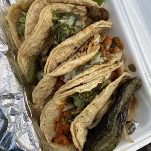 four tacos in a styrofoam container