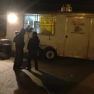 a group of people standing in front of a food truck
