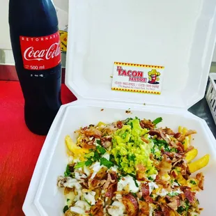 a container of food and a bottle of coke