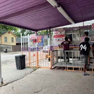 two people standing at a food stand