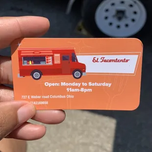 a hand holding a business card